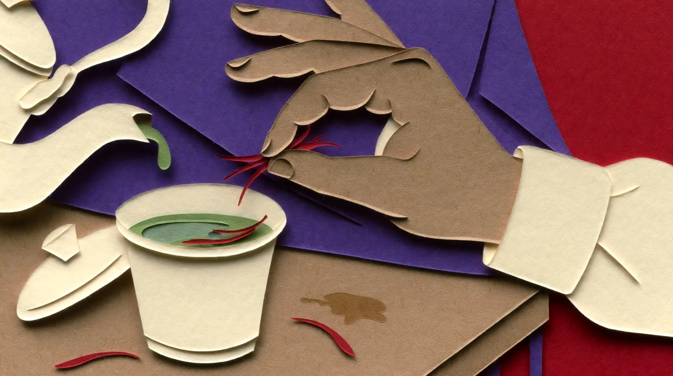 Les bienfaits du thé au safran sont illustrés par une main en papier découpé déposant des filaments rouges dans une tasse.